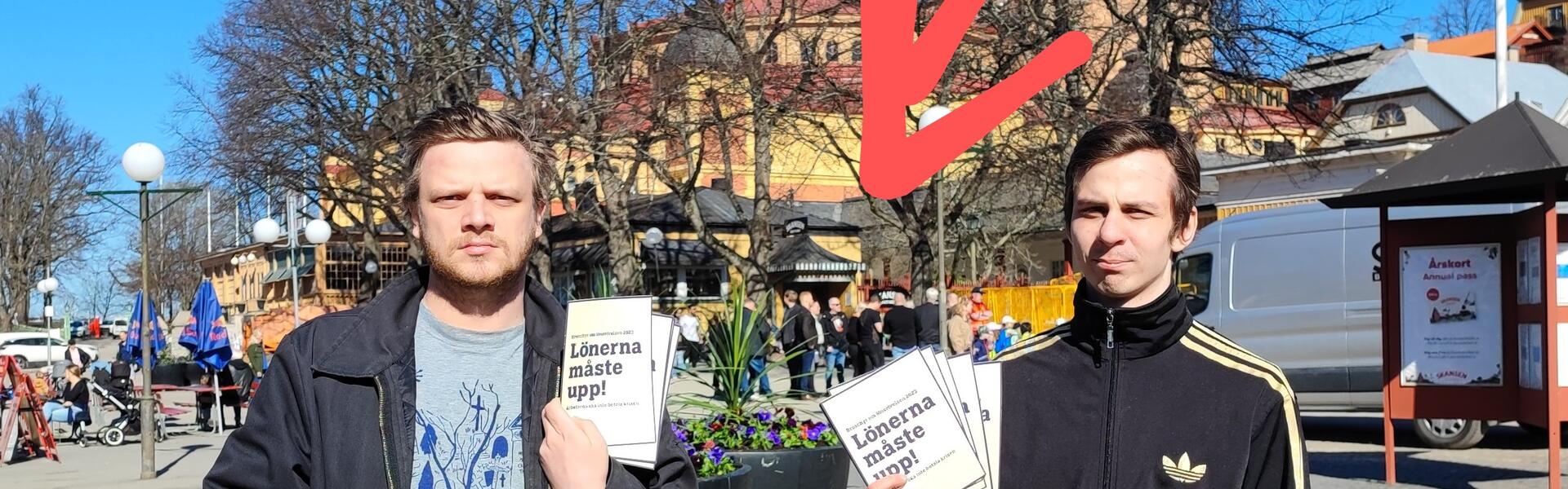 Aktivister håller upp flygbladet "Lönerna måste upp!" framför en delegation av LO-pampar