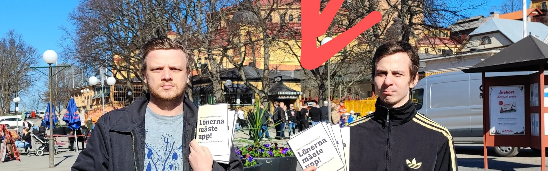 Aktivister h&aring;ller upp flygbladet "L&ouml;nerna m&aring;ste upp!" framf&ouml;r en delegation av LO-pampar