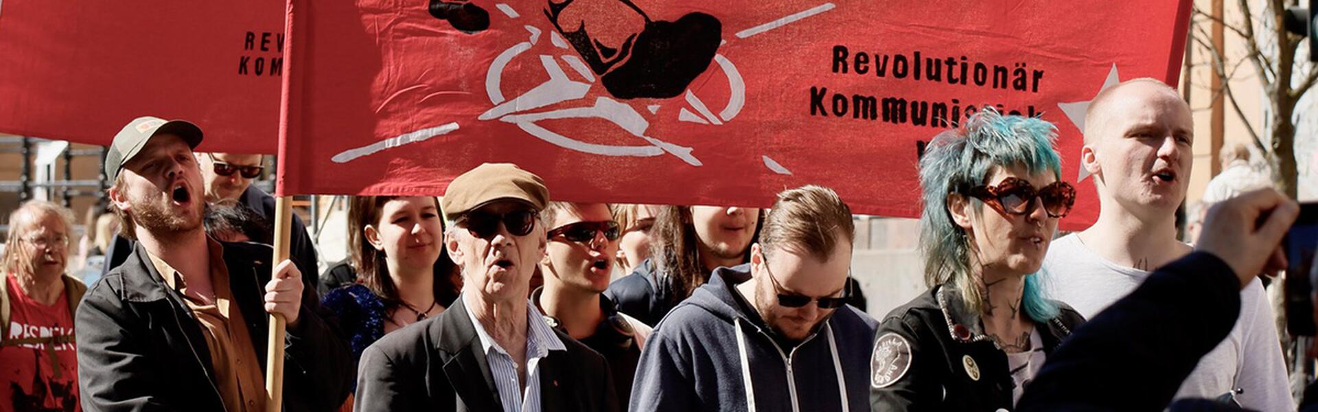 Bild på demonstranter med en banderoll med texten "Nej till Nato! Krig och imperialism är mänsklighetens fiende!"