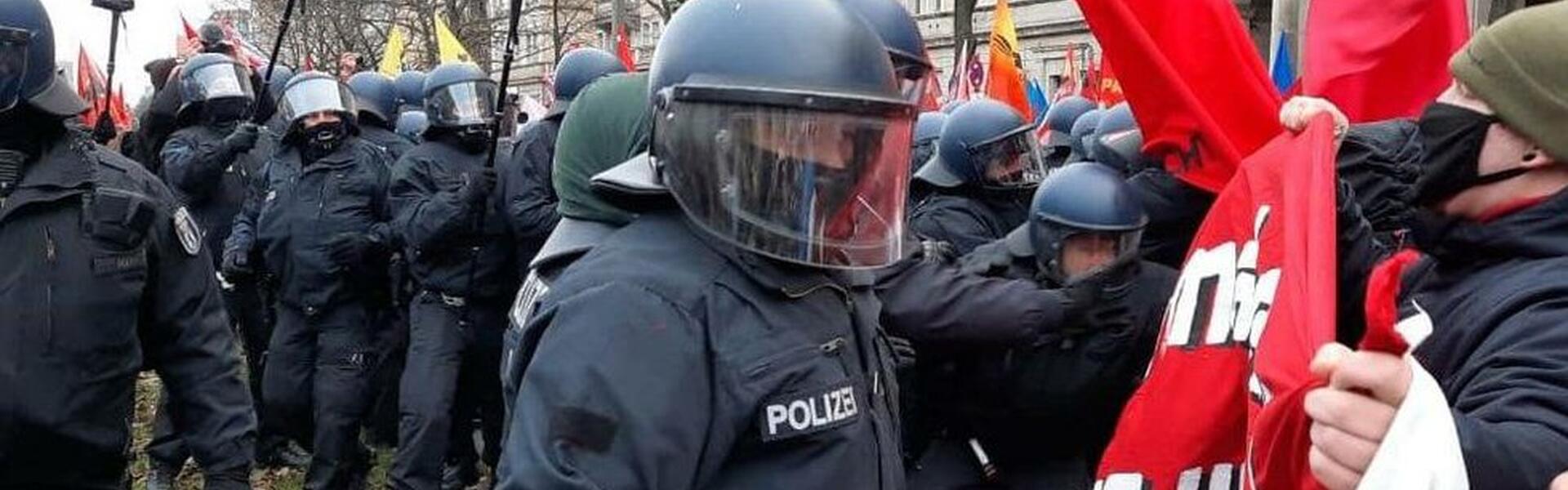Bild på tyskpolis med kravallkläder konfronterande demonstranter vid en demonstration