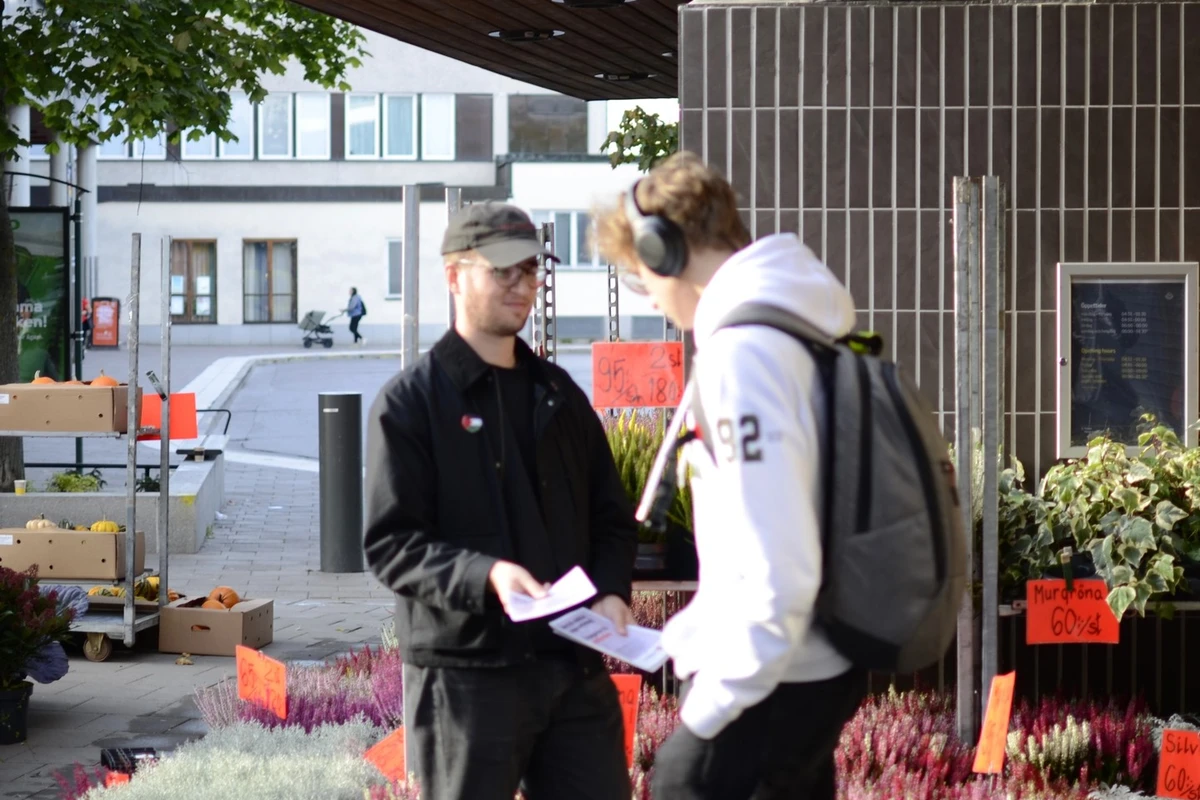 Medlem st&aring;r och delar ut flygblad