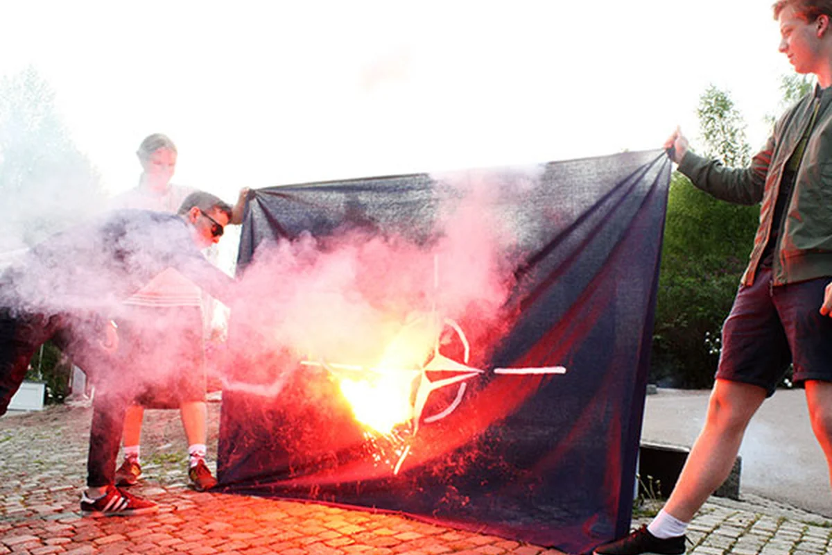 Medlemmar br&auml;nner en Natoflagga