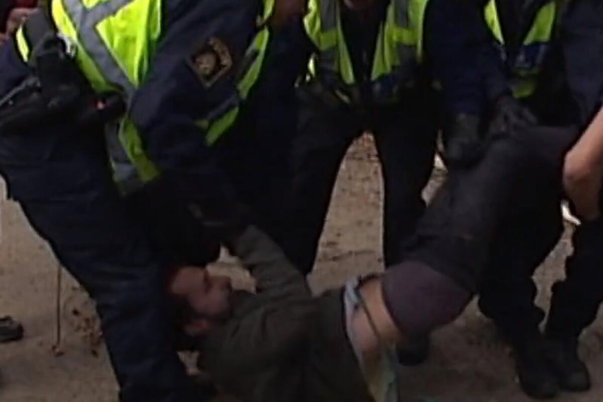 Poliser släpar bort demonstrant