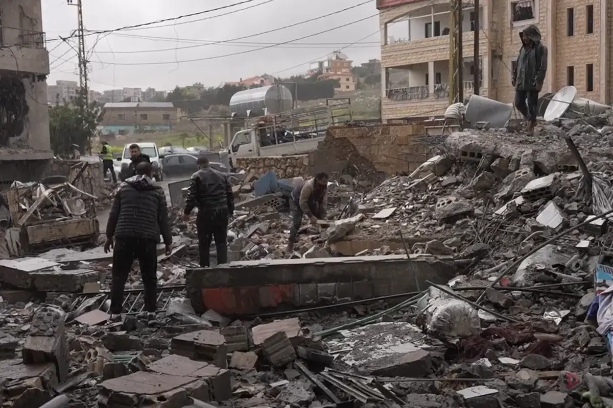 Bild p&aring; familjer som g&aring;r igenom resterna av sina hem efter att de bombats av IDF